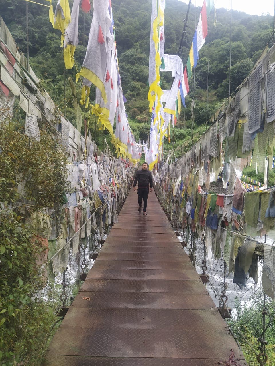 Wooden bridge covered with colourful prayer flags