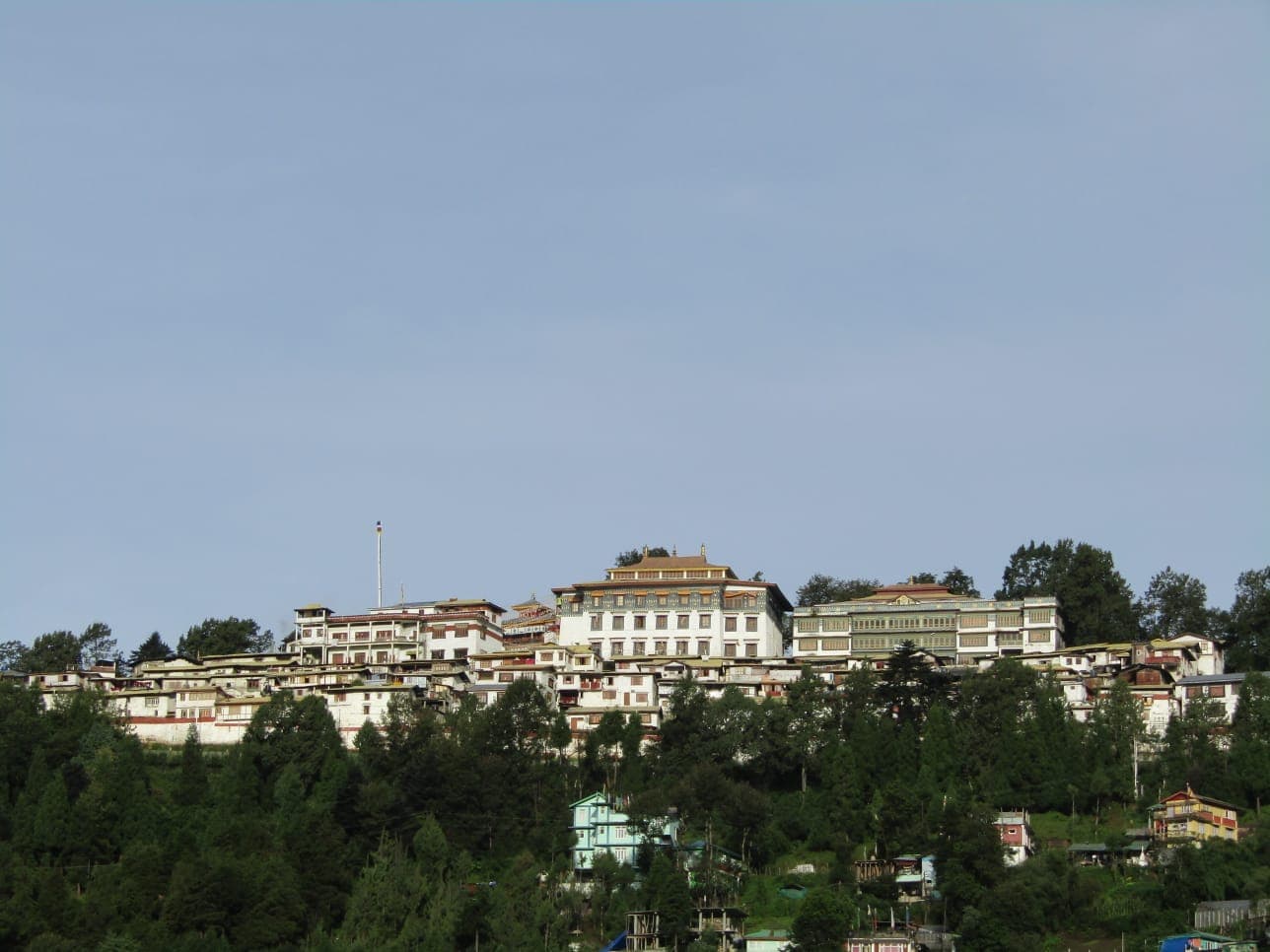 Large monastery complex overlooking a wooded hillside
