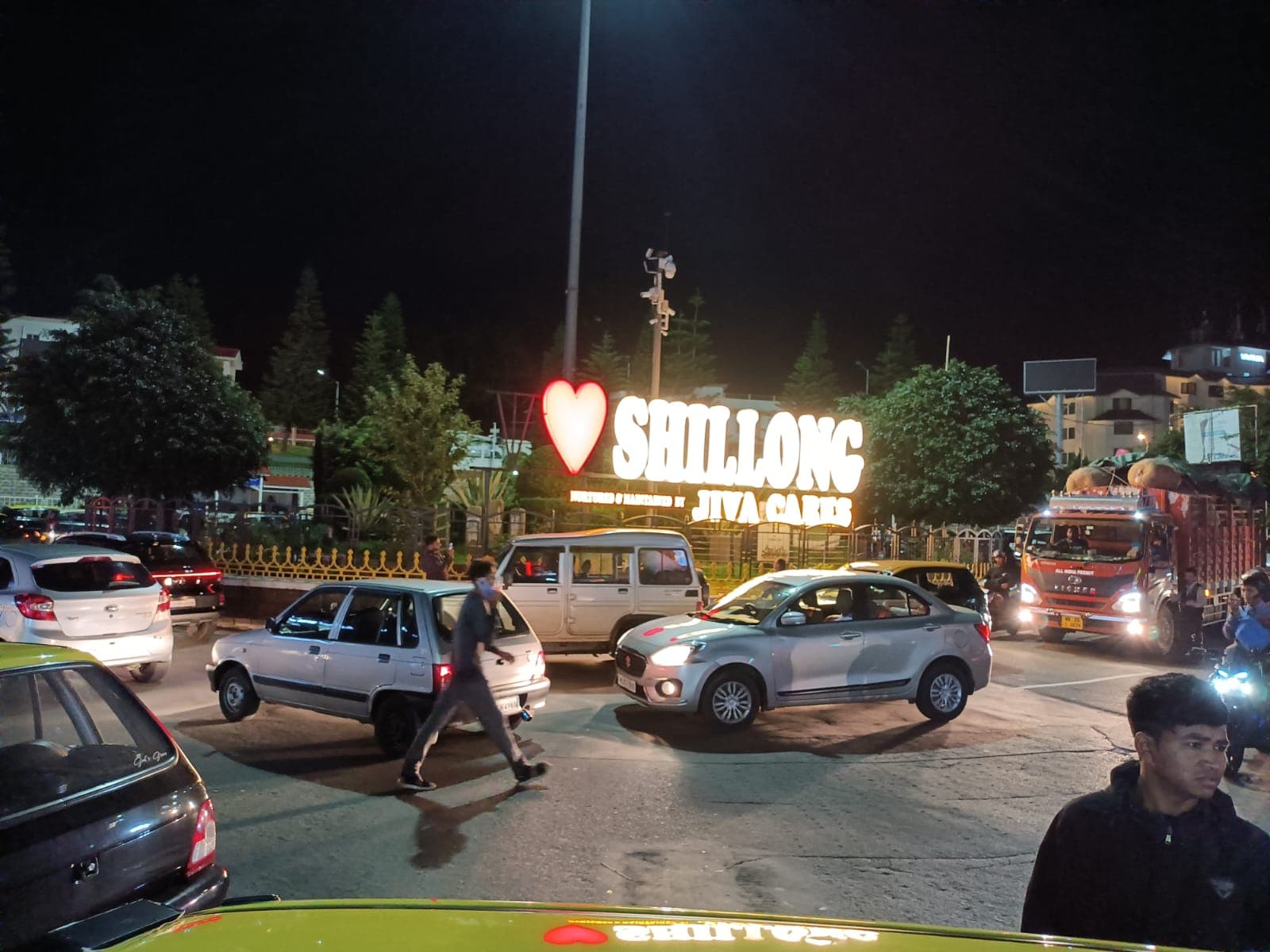 Illuminated I love Shillong sign beside a busy street at night