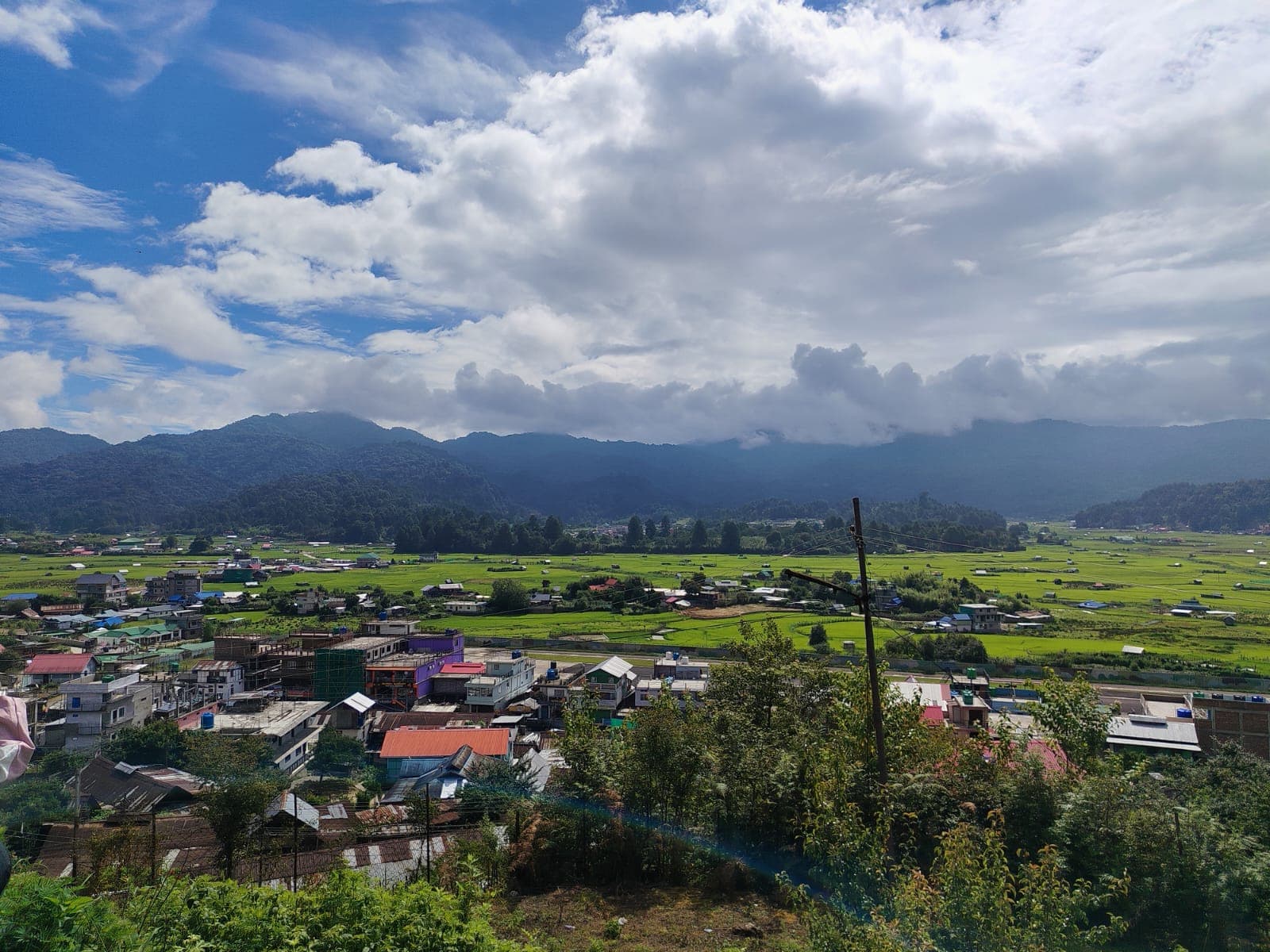 Ziro village and green fields beneath a wide mountain sky